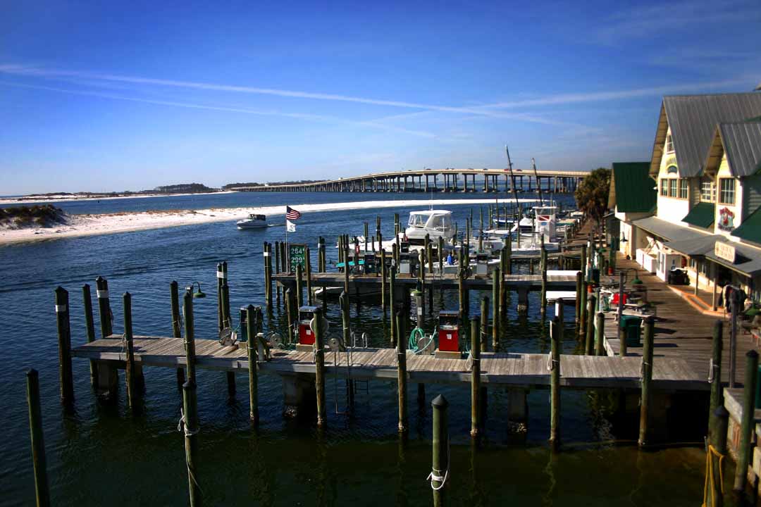 Boats docked at a marina under clear skies