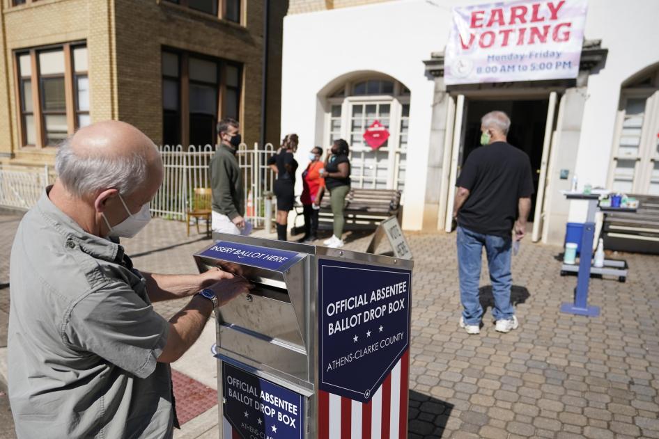 A voter uses an official absentee ballot drop box outside an early-voting site.