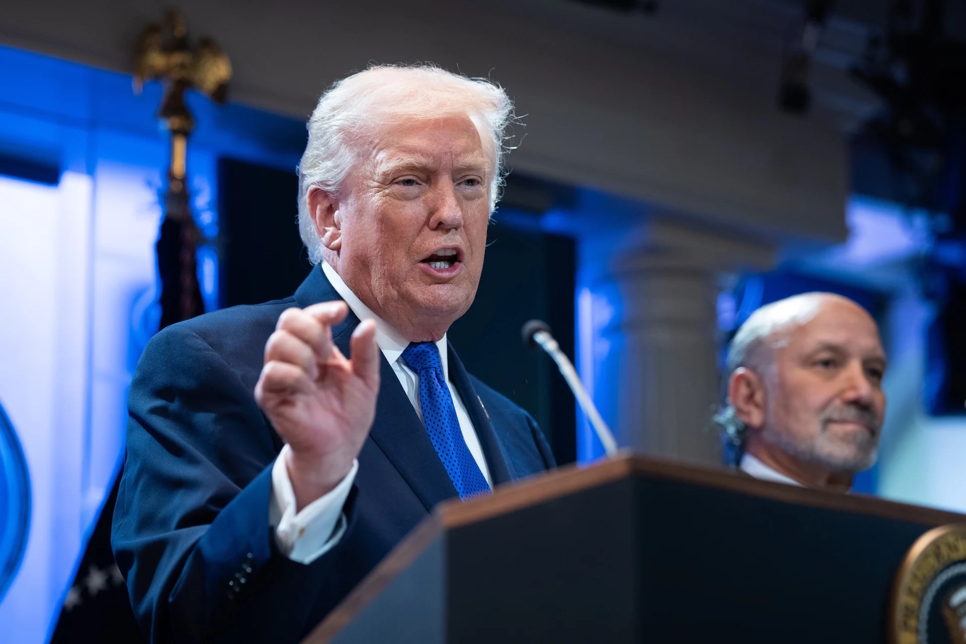 President Donald Trump speaks at a White House podium, February 2026.