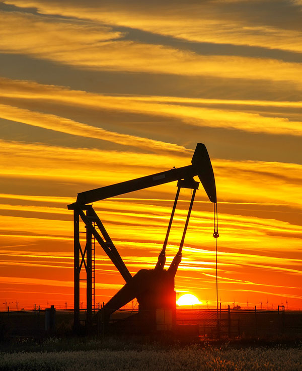 An oil pumpjack silhouetted at sunset
