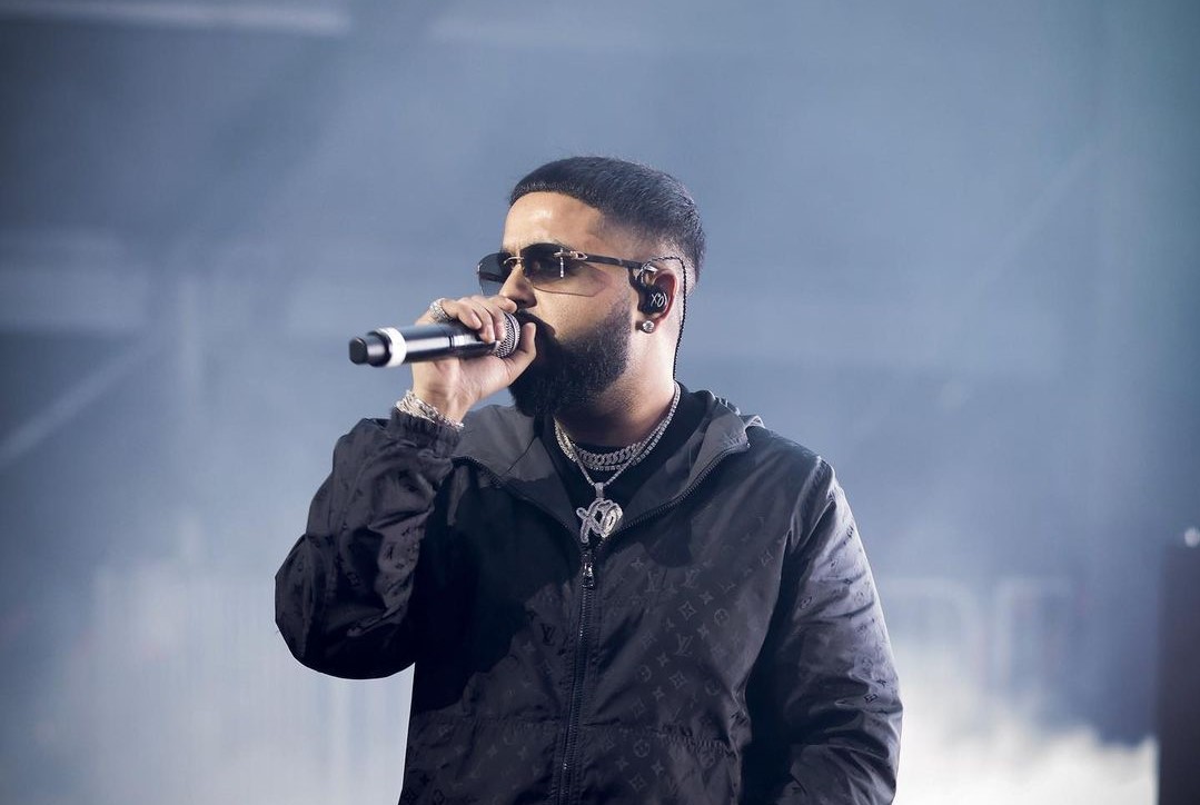 NAV performing on stage with a microphone