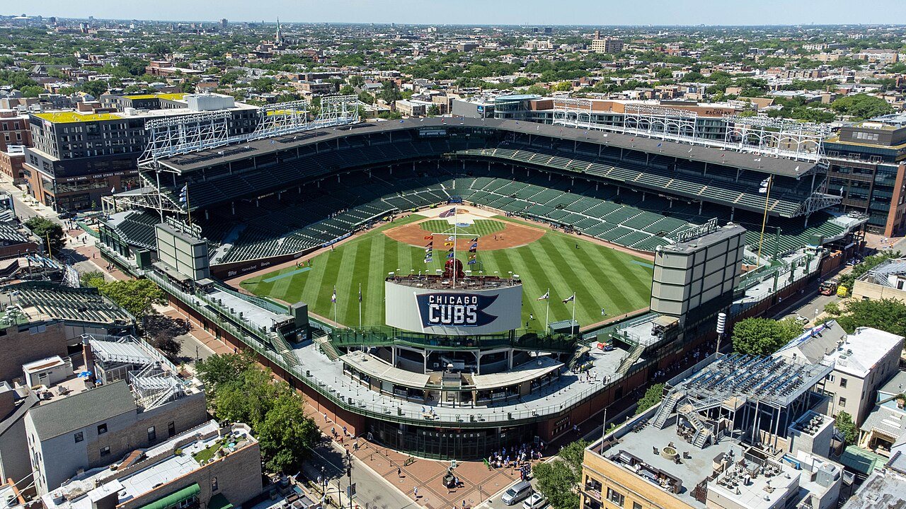 Wrigley Field during a day game, ivy on the outfield walls and a full house